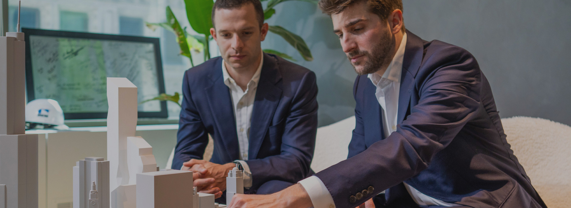 Two GNP Realty employees reviewing an architectural model